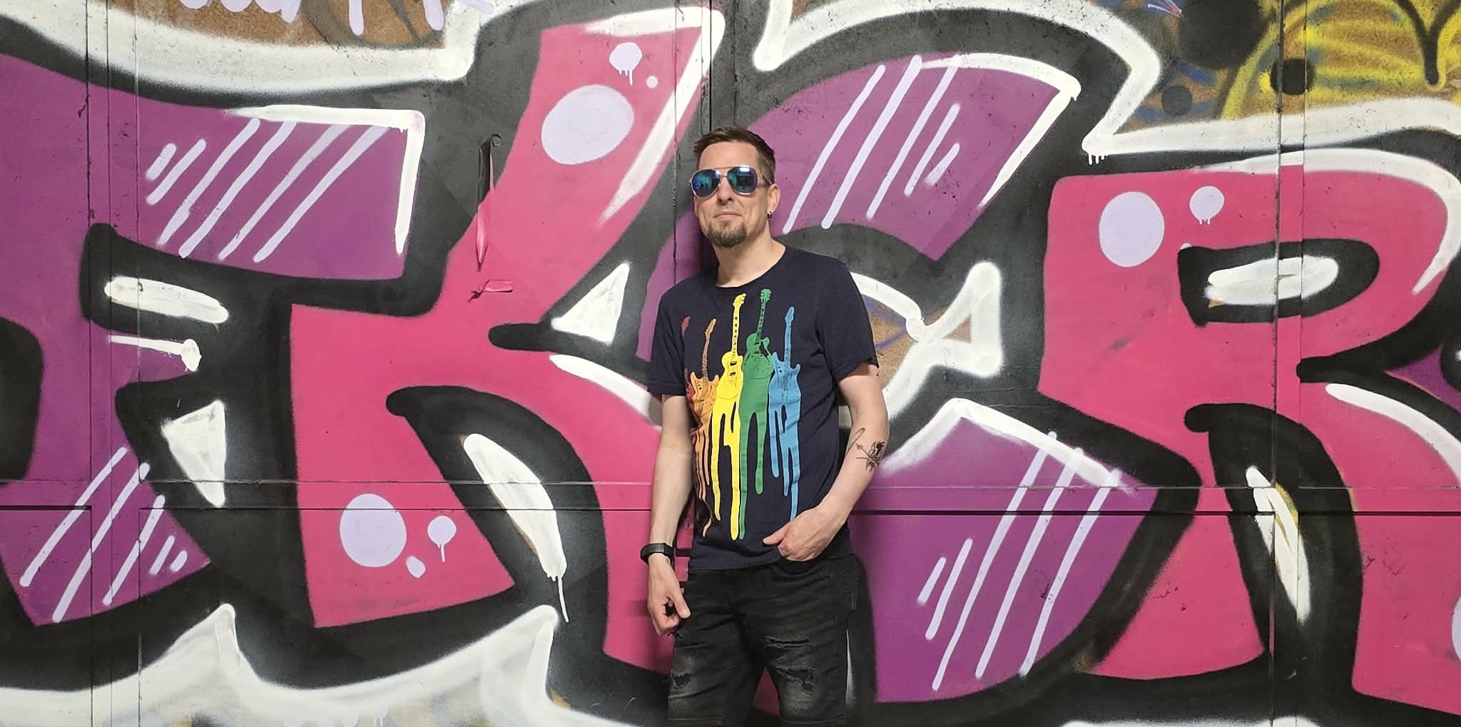 Ronny Trubadur foran rosa graffiti
